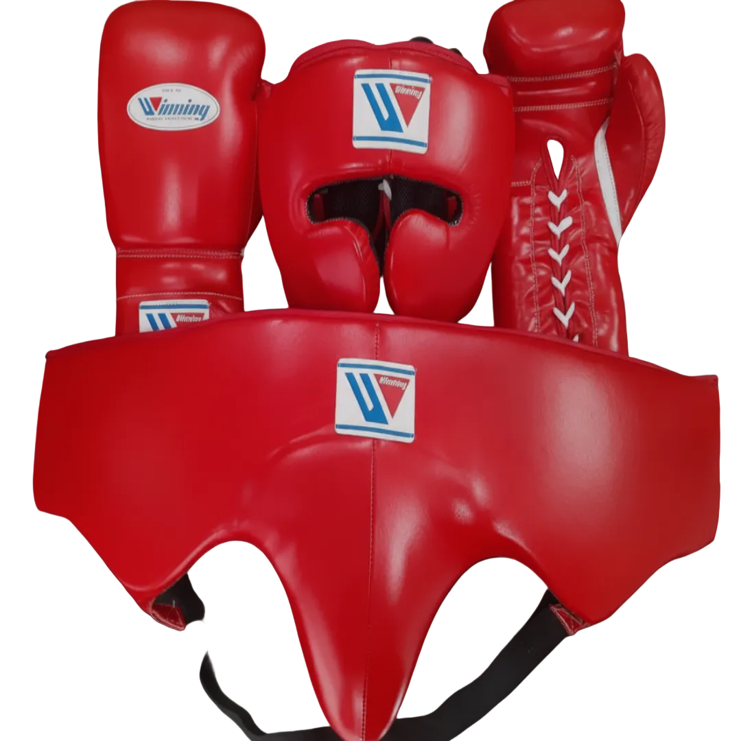 A set of red boxing gear including a headguard, boxing gloves, and a mouthguard, all featuring the Winning brand logo, displayed against a dark background.