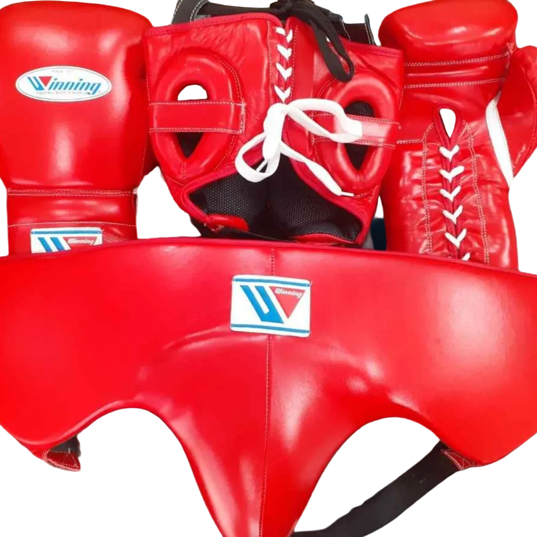 A set of red boxing protective gear including a pair of boxing gloves, a headguard, a chest guard, and a shin guard, all with the Winning brand logo, displayed against a dark background.