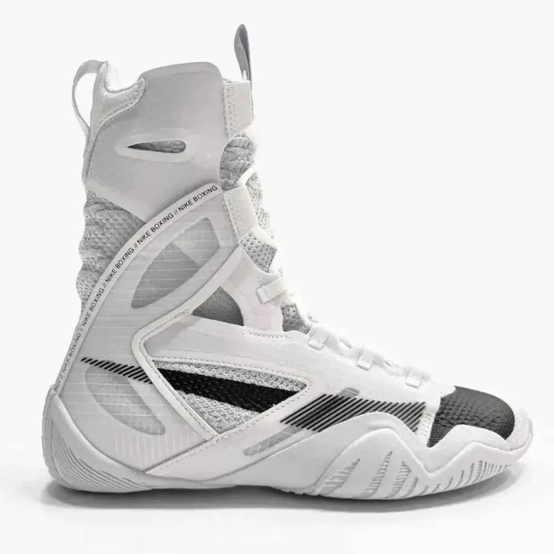 A high-top athletic sneaker in white, gray, and black, featuring a textured mesh and synthetic upper with a lace-up closure, shown from a side profile on a light gray background.