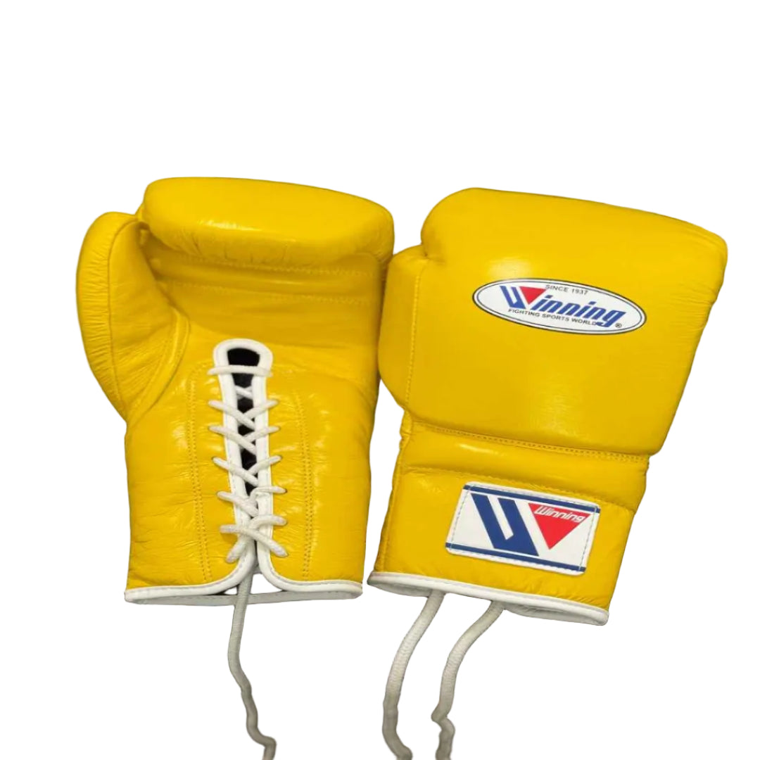 Yellow boxing gloves with a brand logo on a dark surface