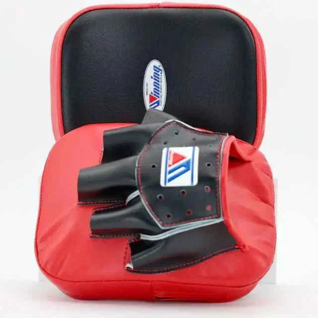 Red boxing mitt with black glove on a white background